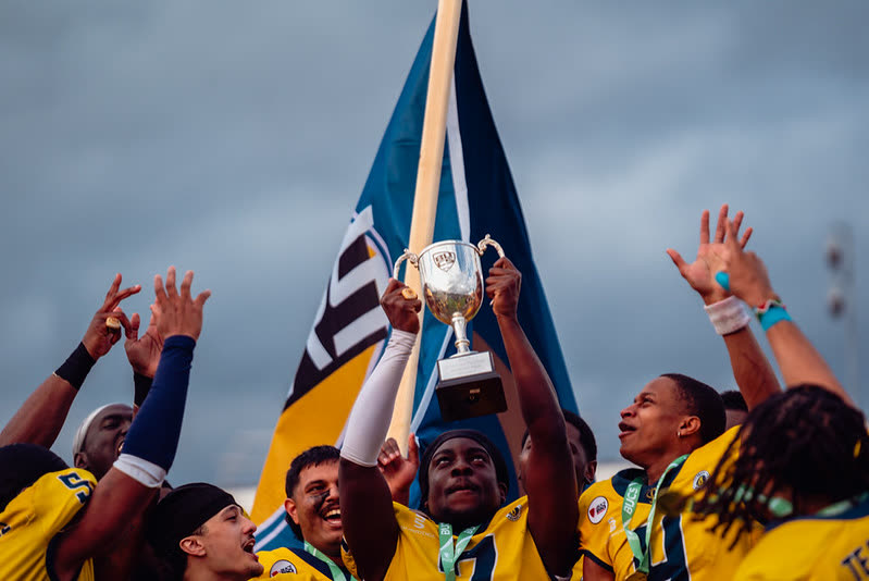 British university American football players lifting a BUCS trophy